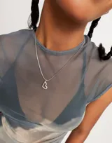 Dije charm con forma de corazón abierto, bañado en plata de ley.