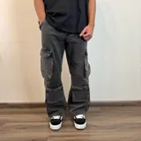 Pantalón de jean estilo cargo con corte baggy, color azul lavado. Presenta cuatro bolsillos laterales de gran tamaño con solapa y cierre de botones, diseño de pierna ancha y tiro medio.