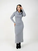 Vestido largo de punto color gris, con cuello tipo polera holgado y mangas largas. Presenta un corte ajustado al cuerpo y diseño minimalista.