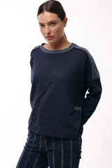 Remera de silueta relajada, confeccionada en tejido de punto, con cuello redondo, mangas largas y un bolsillo aplicado en el frente.