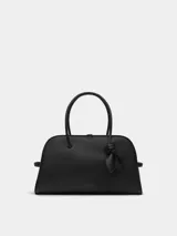 Cartera Jacquemus modelo Le Turismo de piel graneada color negro, con cierre de cremallera bidireccional, doble asa de mano y detalle de lazo en una de las asas.