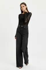 Pantalon jean de corte baggy y tiro alto, color negro, con diseño de pierna ancha y terminación deshilachada en el ruedo.