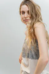 Pijama de dos piezas, compuesto por una musculosa blanca con detalle de puntilla negra elástica en el escote y un short blanco con elástico y lazo negro en la cintura.