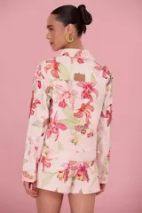 Chaquetas de jean color rosa con estampado floral de orquídeas y detalles de strass. Presenta cuello solapa, cierre frontal con botones metálicos y bolsillos frontales con solapa.