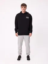 Canguro negro con capucha y estampado blanco en la espalda que incluye el logo de Rusty, texto y gráficos de peces.