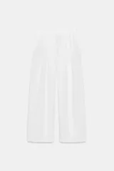Pantalón de tiro medio confeccionado en 100% lino. Presenta cintura elástica con trabillas, bolsillos laterales, detalle de pinzas en el delantero y cierre frontal con cremallera y botón.