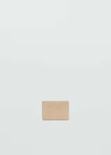Porta tarjetas de diseño minimalista en color beige, con múltiples ranuras y logo de la marca grabado en la parte frontal.