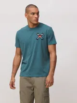 Remera de algodón orgánico color blanco, con corte regular fit y detalle de bordado en forma de X con diseño geométrico multicolor en el pecho.