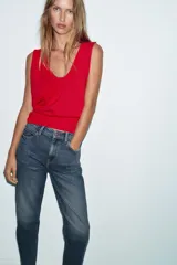 Jeans de tiro alto con corte mom fit, cinco bolsillos y cierre frontal con cremallera y botón.
