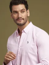Camisa de hombre de manga larga en color rosado, confeccionada en algodón. Presenta cuello con botones (button-down) y un corte slim fit.