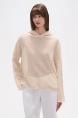 Canguro de tejido de punto calado en color crudo, con capucha, mangas largas y corte holgado.