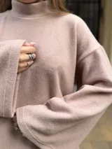 Polerón de cuello alto en color rosa, con diseño de calce holgado y mangas amplias. Confeccionado en tela suave y abrigada, ideal para un estilo urbano y relajado.