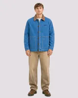 Campera estilo workwear de Denali, confeccionada en canvas resistente color azul medio. Presenta cuello de pana en tono marrón, cierre frontal con botones metálicos y dos bolsillos frontales amplios. Incluye bordado de la marca en el pecho.