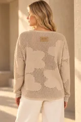 Buzo de tejido de punto calado color celeste, con diseño de flores, escote redondo y mangas largas.