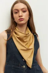 Pañuelo de cuello de tela suave y ligera en color beige, con diseño liso y terminaciones simples.