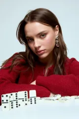 Cardigan corto de punto color rojo, con cierre frontal y cuello redondo. Presenta una textura acanalada y mangas largas.