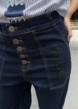 Jean 2 en 1 de color azul oscuro, con corte wide leg transformable a babucha mediante ajuste en los tobillos, tiro alto con cierre frontal de múltiples botones metálicos y bolsillos delanteros destacados.