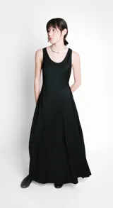 Vestido largo negro evasé de tela ligera y fluida, con escote redondo y sin mangas.