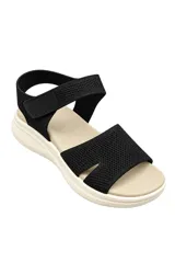 Sandalia de lycra negra con tira ajustable de velcro en el empeine, plantilla acolchada beige y suela chunky de goma blanca con relieve.