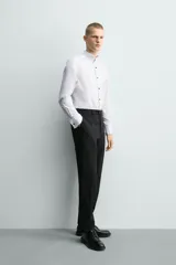 Camisa slim fit de algodón con cuello smoking, manga larga con puño doble para gemelos y pechera combinada a tono con cierre frontal de botones.