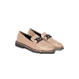 Mocasines de cuero vacuno color visón, con costuras visibles en la parte superior y un adorno metálico negro en el empeine. Poseen suela baja y diseño sin cordones.