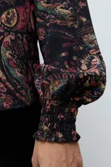 Camisa de manga larga con estampado estilo paisley en tonos oscuros, cuello clásico y puños ajustados.