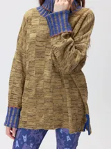 Pullover de punto jacquard color tostado con cuello alto y puños acanalados en tono azul y detalles en naranja. Cuenta con aberturas laterales y calce holgado.