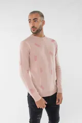 Sweater de tejido de punto en color rosa claro con estampado de pequeñas piñas en tono más oscuro. Presenta escote redondo, mangas largas y puños acanalados.