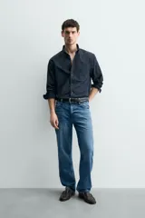 Camisa de corte regular fit confeccionada en tejido de algodón. Presenta cuello con solapa abotonada, cierre frontal con botones, manga larga con puños abotonados y un bolsillo plastrón en el pecho.