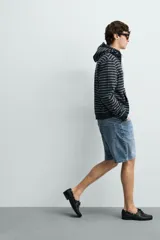 Bermuda de jean con corte regular fit, confeccionada en denim de algodón con elasticidad. Presenta diseño de cinco bolsillos, efecto lavado y cierre frontal con cremallera y botón.