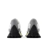 Championes New Balance modelo 327, color gris y blanco, con capellada de malla y superposiciones de gamuza, logo "N" asimétrico en el lateral y suela de goma con diseño texturizado.