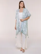 Kimono de gasa ligera con estampado floral en tonos de azul y blanco, silueta amplia, mangas cortas y detalle de borlas en el ruedo asimétrico.