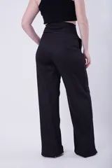 Pantalón de vestir negro de tiro alto y corte palazzo, con bolsillos laterales.