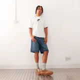 Camiseta tipo polo de manga corta, color blanco, confeccionada en tejido de malla perforada. Presenta cuello con ribete negro y logo "Nike Air" estampado en el pecho en color negro.