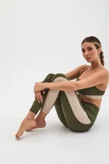 Calza deportiva larga color verde militar con panel lateral color beige.