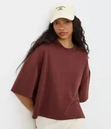 Remera de modal color crudo, con diseño minimalista, calce amplio, cuello redondo y mangas cortas amplias con hombros caídos.
