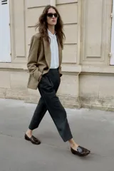 Pantalón de tiro medio con pinzas delanteras y pernera recta. Cuenta con bolsillos frontales, falsos bolsillos traseros de vivo y cierre frontal con cremallera, botón interior y ganchos.
