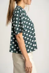Remerón verde con lunares blancos, de calce oversize y mangas cortas.