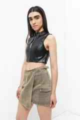 Minifalda de jean color marrón con efecto gastado, corte asimétrico, bolsillos de parche con solapa y tiras ajustables con hebillas en los laterales.