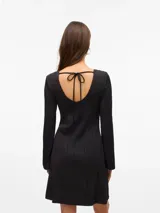 Vestido midi de color negro con textura acanalada ondulada, cuello redondo y mangas largas. Presenta un diseño ajustado al cuerpo con una caída fluida.