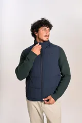 Chaleco puffer de color azul marino, con cierre frontal completo y cuello alto. Presenta un diseño acolchado horizontal y el logo de la marca bordado en el pecho.