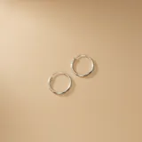 Par de aros tipo argolla de diseño clásico y minimalista, fabricados en plata 925 con acabado pulido.