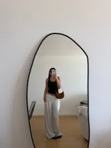 Pantalón negro de algodón y viscosa, con estampado de lunares blancos y corte holgado.