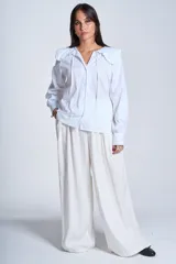 Camisa blanca de manga larga con cuello Claudine y lazos en el escote.