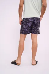 Short de baño negro con estampado de hojas y flores violetas, con cintura elástica y cordón ajustable.