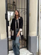 Camisa negra de tejido de punto con detalles en cuero color plata en cuello, solapa, puños y bolsillos.