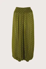 Pantalón de corte holgado y diseño tipo bombacho, color verde con estampado de pequeños puntos dorados. Presenta cintura elástica fruncida y puños elásticos en los tobillos.