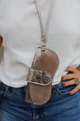 Cuelga lentes de cuero rojo con correa fina y botón metálico.