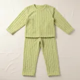Conjunto de pijama de dos piezas confeccionado en plush suave con textura de ochos. Incluye una remera de manga larga con cuello redondo y un pantalón de corte recto con cintura elástica.