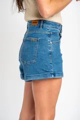 Short de denim azul de tiro medio, con bolsillos delanteros y traseros, cierre de botón y cremallera, y botamangas con dobladillo.
